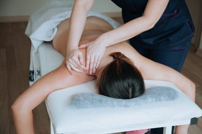 Women laying in massage bed, while getting back massage.